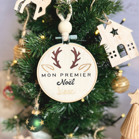 Boule de Noël suspendue dans le sapin, personnalisée avec le prénom de bébé et un joli motif de petit cerf de Noël.