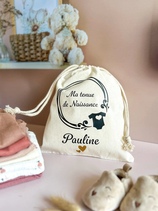 Pochon en coton naturel avec l'inscription “Ma tenue de naissance” et prénom personnalisé, idéal valise maternité.