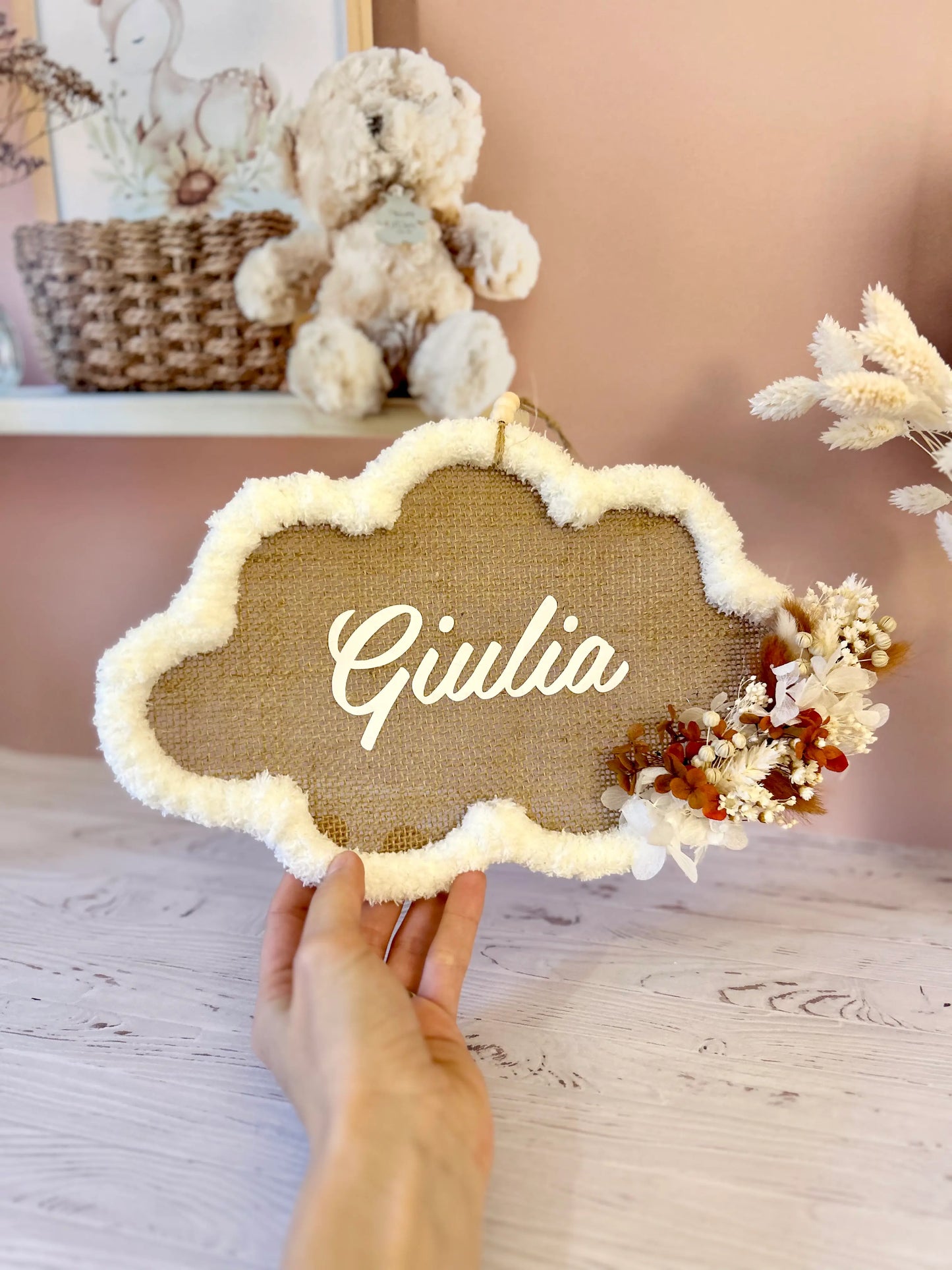 Grand cadre nuage personnalisé avec le prénom de bébé, orné de fleurs séchées aux tons blanc et terracotta, une décoration naturelle et tendance pour la chambre.