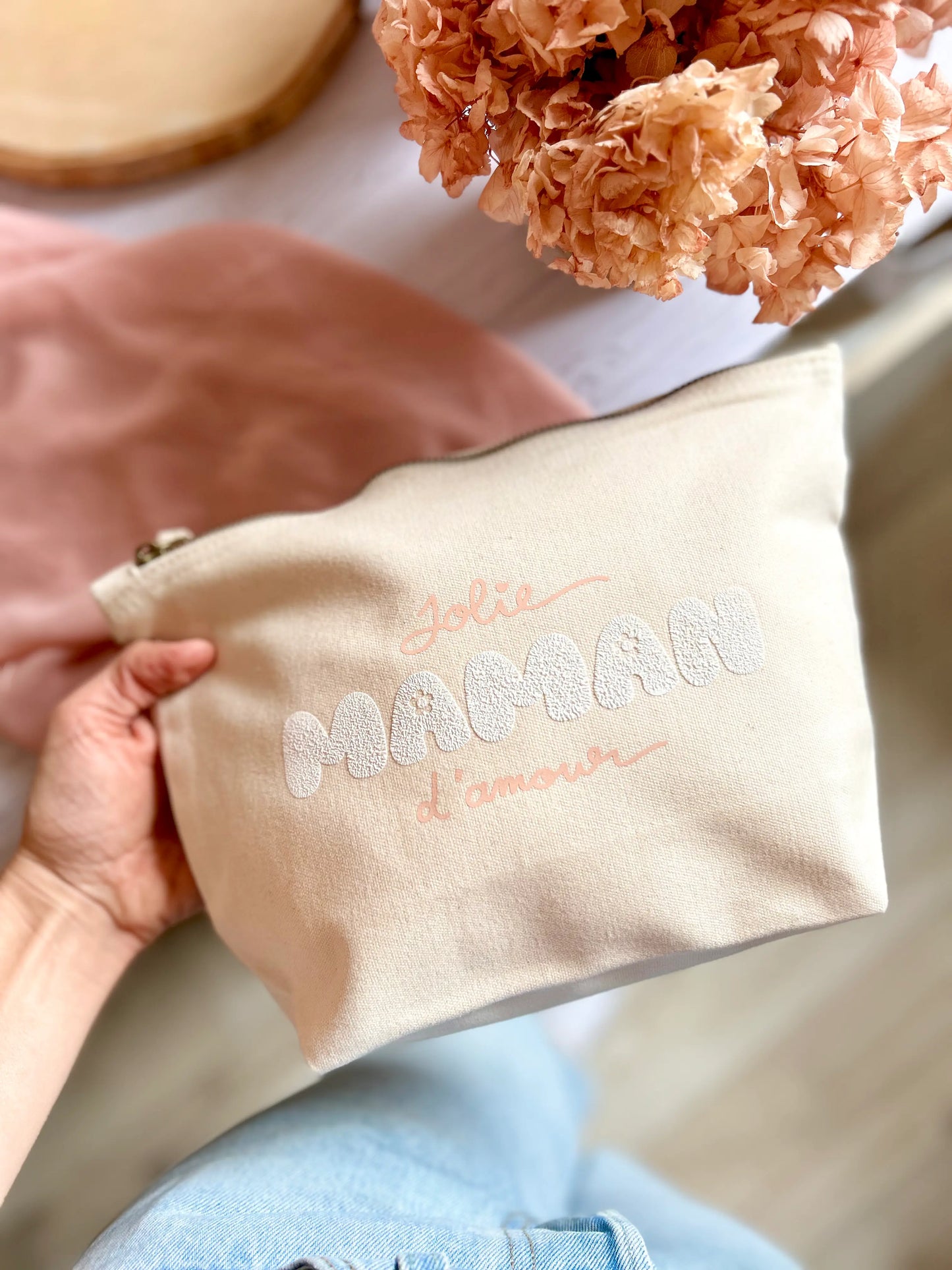 Gros plan sur le flocage printanier rose pastel “maman”, sur toile écrue.
