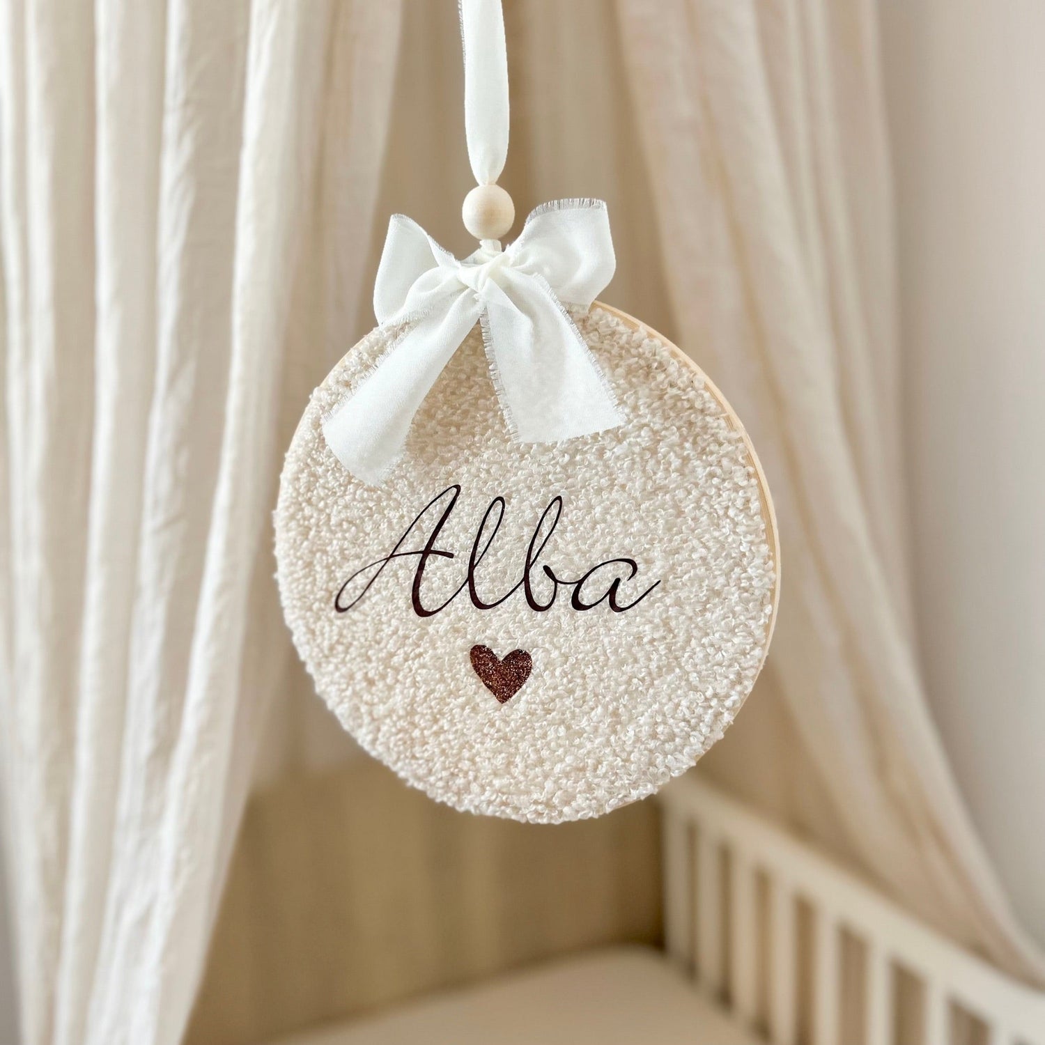 Suspension murale personnalisé au prénom de bébé, réalisée sur un cercle à broder avec un tissu bouclette, tons écru et beige.