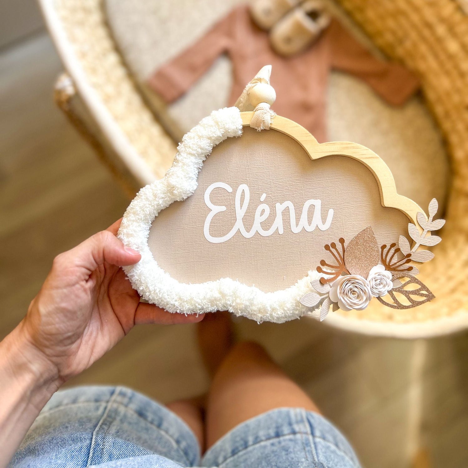 Nuage décoratif personnalisé avec le prénom de bébé, présenté au dessus d'un couffin pour cadeau de naissance original.