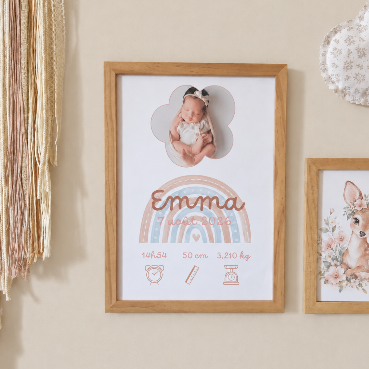 Affiche de naissance encadré avec thème arc-en-ciel rose pastel et terracotta, présentée dans une chambre de bébé sur un mur beige lin