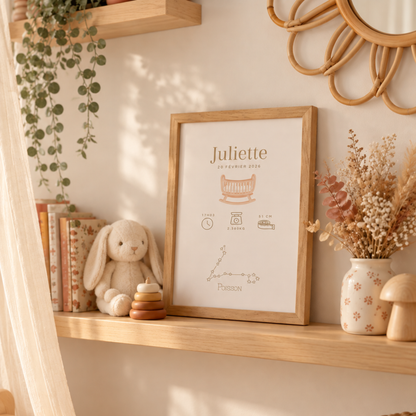 Affiche souvenir de naissance personnalisée avec prénom, informations de bébé et constellation posée sur une étagère en bois avec de la décoration pour la chambre de bébé : miroir fleur en rotin, doudou et ciel de lit.