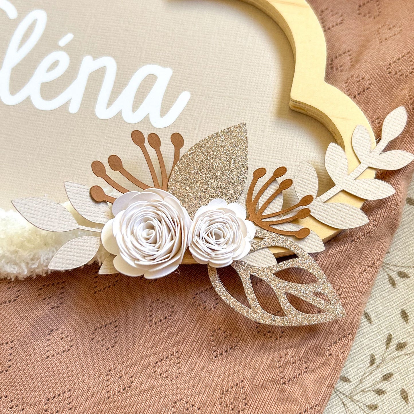 Détails des fleurs qui compose la suspension murale à offrir en cadeau de naissance personnalisé avec le prénom de bébé pour la décoration de la chambre.