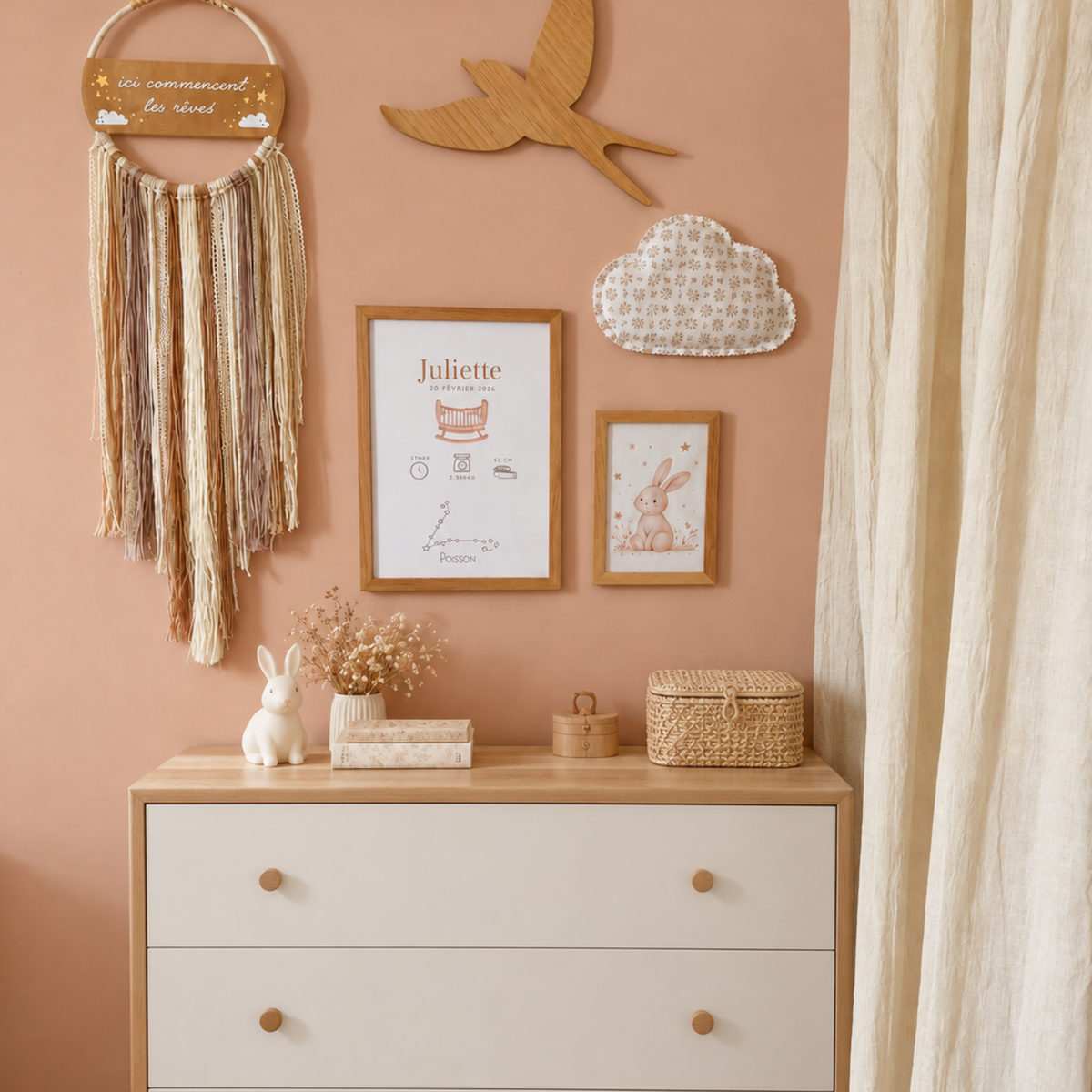 Affiche de naissance personnalisée avec prénom et constellation présentée dans une chambre de bébé au dessus d'une commande bois et blanc. L'affiche est accrochée au mur aux cotés d'un nuage en tissu, d'une illustration pour bébé, d'une hirondelle en bois et d'un attrape-rêves bohème.