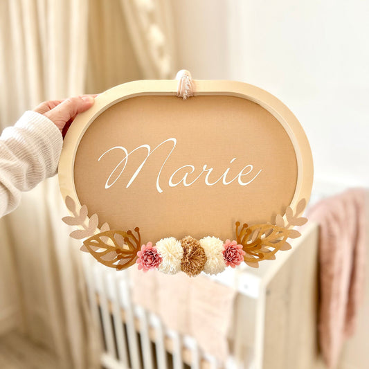 Cadre ovale personnalisé en bois avec pompons coton et fleurs papier, décoration murale pour chambre bébé, idéal à offrir en cadeau de naissance.