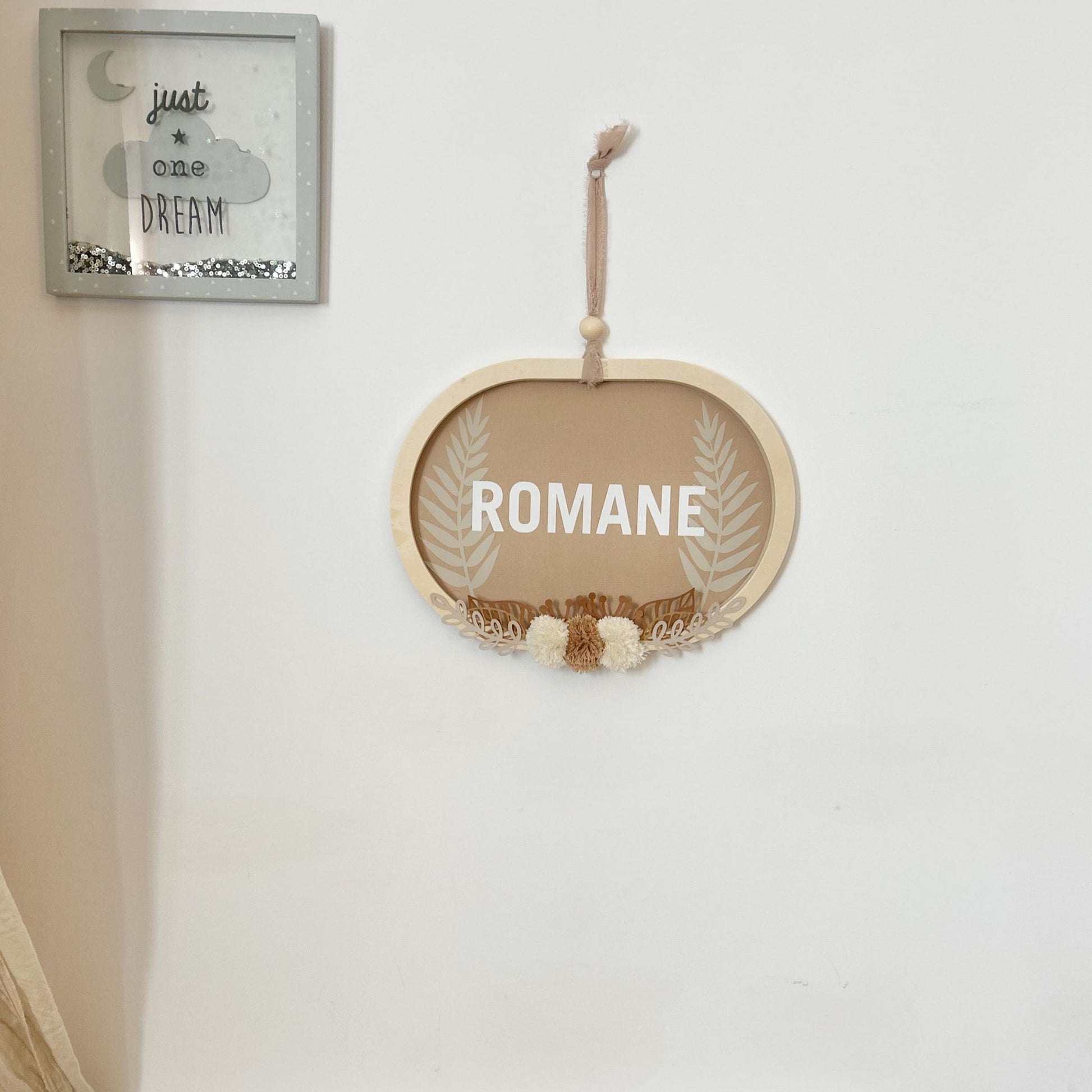 Cadre ovale personnalisé avec le prénom, suspendu au mur, décoration chambre bébé aux tons lin naturel et brun noisette.