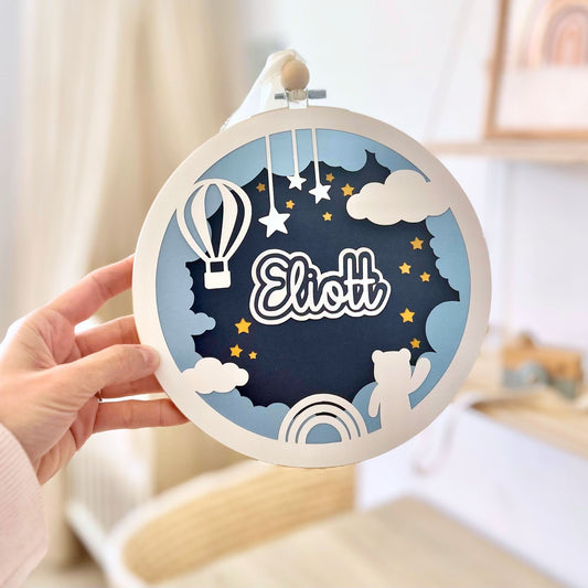 Cadre relief personnalisé avec prénom bébé, décoration murale poétique pour chambre de bébé garçon, avec montgolfière et nuages.