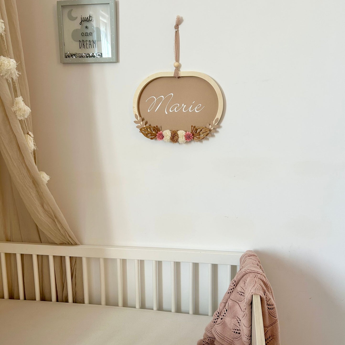 Grand cadre mural personnalisé prénom pour une décoration de chambre bébé aux tons naturels et bois.