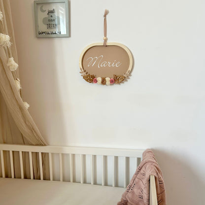 Grand cadre mural personnalisé prénom pour une décoration de chambre bébé aux tons naturels et bois.