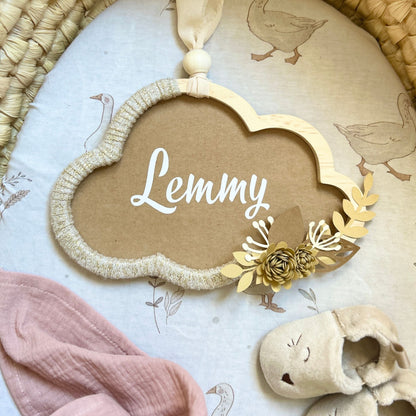 Décoration chambre bébé aux tons naturels avec nuage en bois personnalisé et ruban textile recyclé beige et doré.
