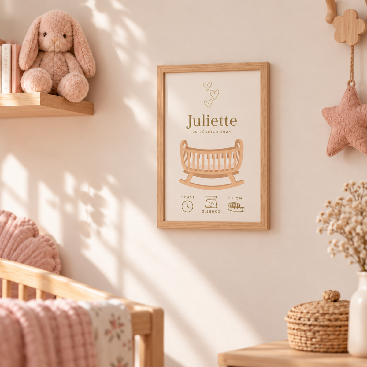 Affiche de naissance personnalisée intégrée dans une chambre de bébé fille aux tons beige, bois et rose poudré