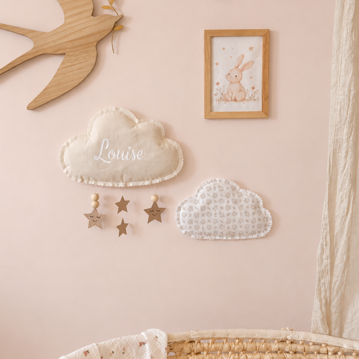 Duo de nuages muraux en tissu personnalisé sur un mur rose poudré dans une chambre de bébé