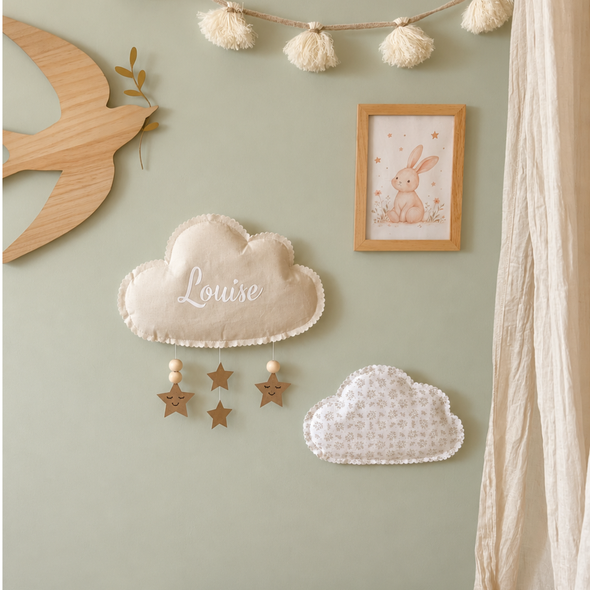 Duo de nuages en tissu personnalisé sur un mur vert sauge dans une chambre de bébé