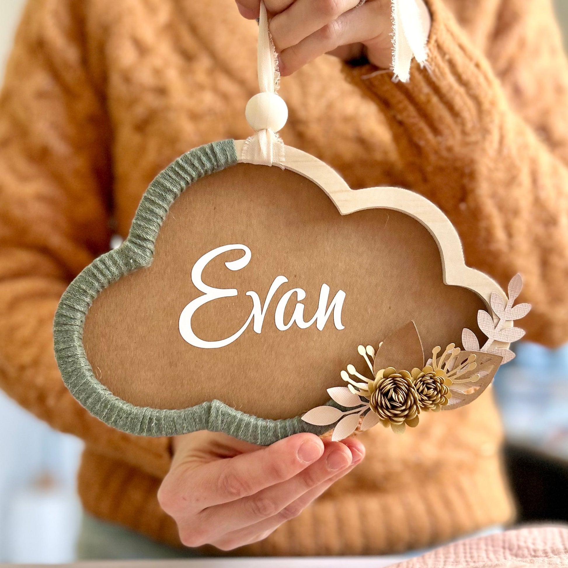 Couronne fleurie en forme de nuage, avec le prénom de bébé, idéale pour offrir en cadeau de naissance fait main.