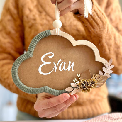 Couronne fleurie en forme de nuage, avec le prénom de bébé, idéale pour offrir en cadeau de naissance fait main.