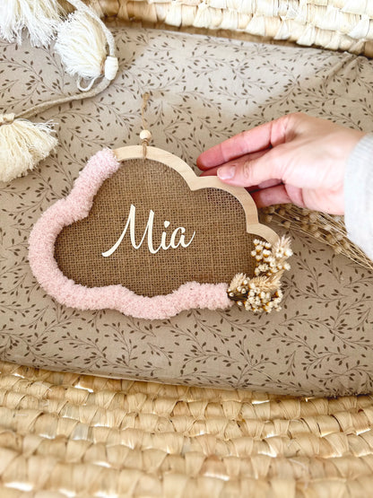 Vue du cadre nuage dans un couffin de bébé, mettant en valeur sa laine rose et ses fleurs séchées pour une touche bohème et raffinée.