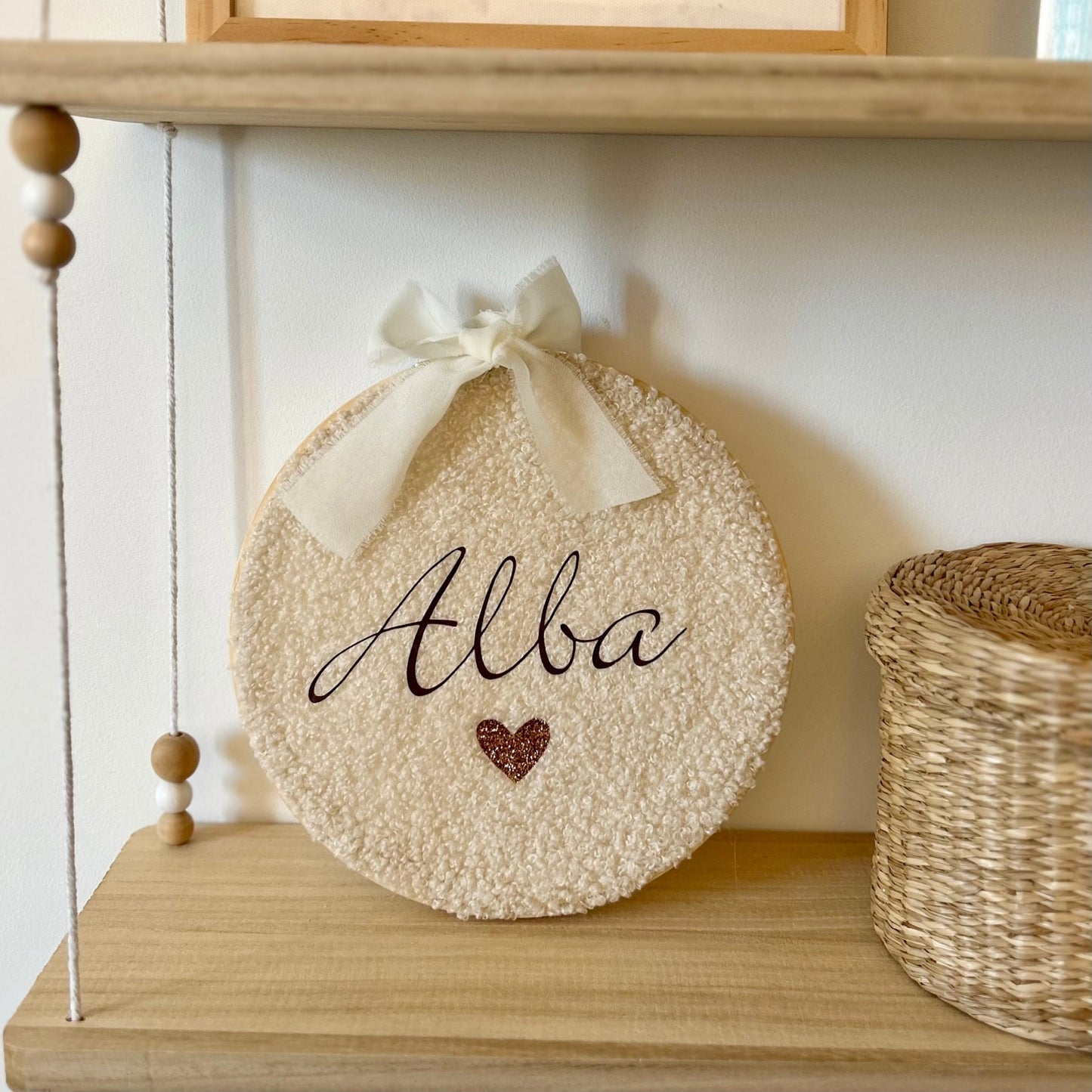 Prénom bébé personnalisé sur cercle à broder en tissu bouclette style cocooning, posé sur une étagère, idéal en cadeau de naissance pour la décoration de la chambre de bébé.