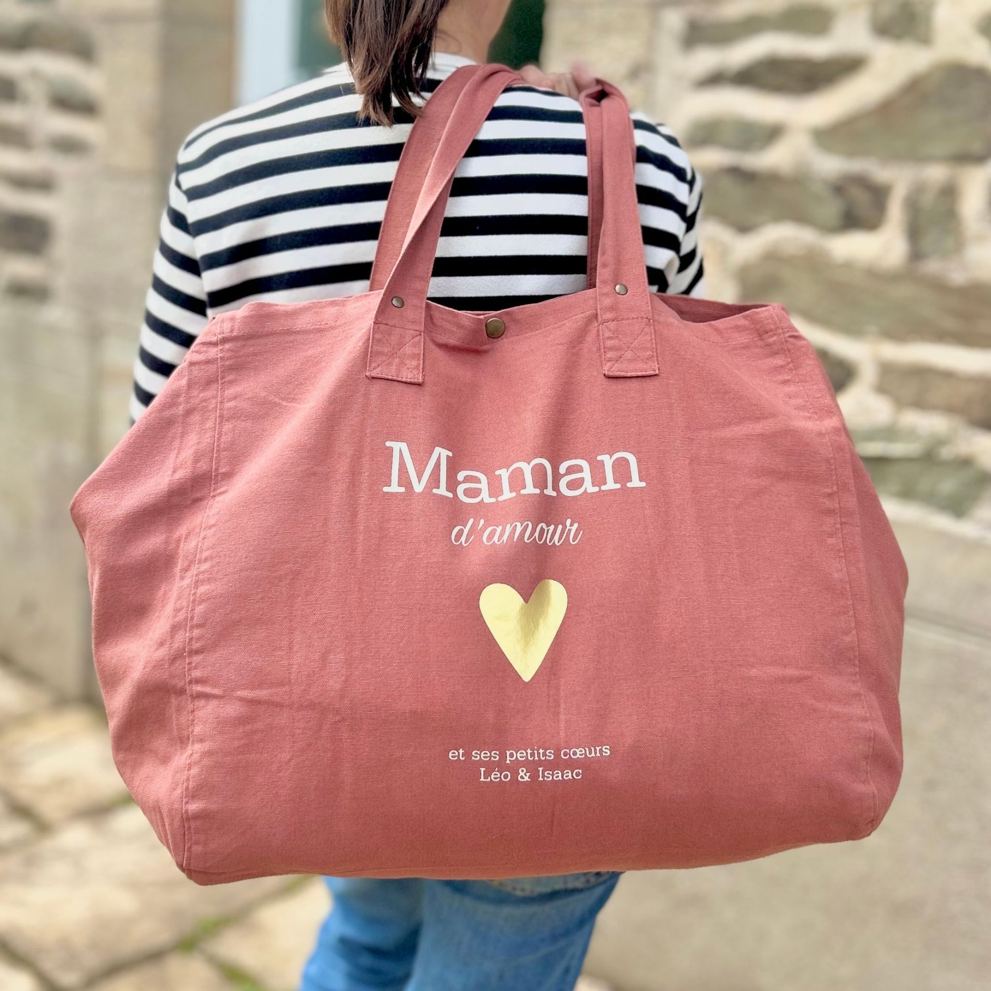 Sac cabas fourre-tout personnalisé avec l’inscription maman d’amour et le prénom des enfants. Sac parfait à offrir en cadeau fête des mères, pour transporter les affaires du quotidien.