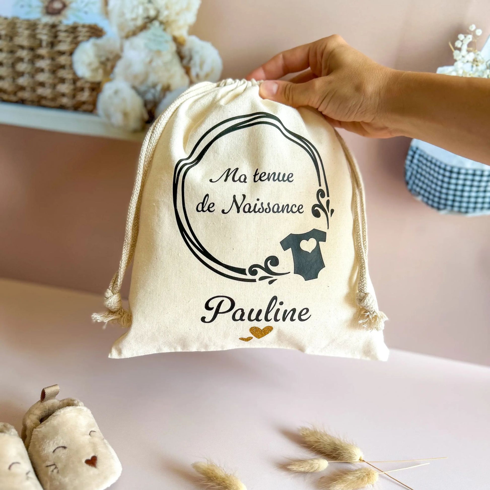 Pochon personnalisé avec le prénom de bébé, à offrir en cadeau de naissance pour garder en souvenir la première tenue de naissance de bébé.