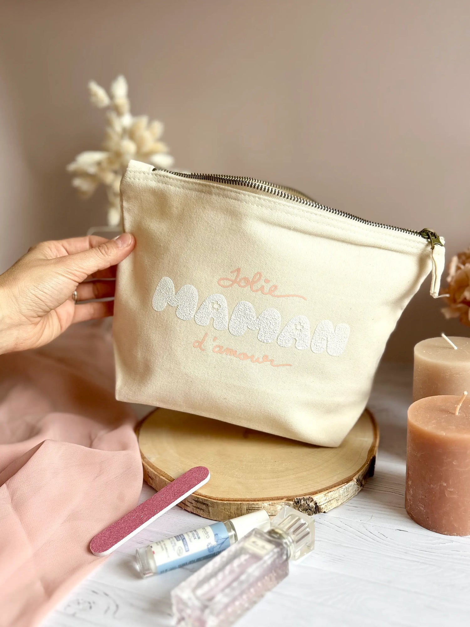 Trousse en coton écru avec flocage rose pastel “jolie maman d’amour”, vue globale sur table.